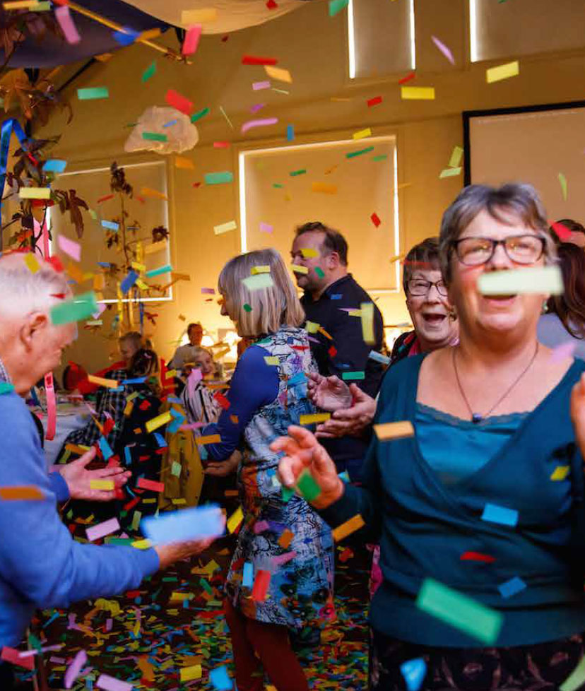 Confetti falling around people who are happily dancing.