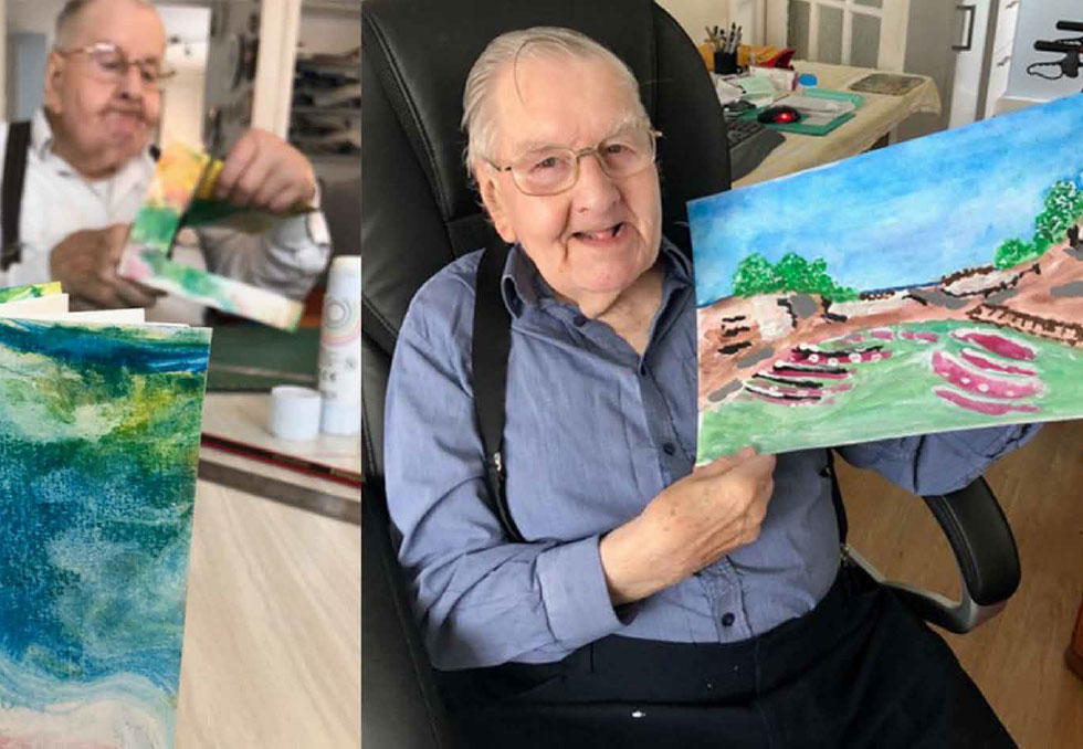 zest-at-home-3 A collage featuring a man holding up artwork he has created. He is sitting down, smiling at the camera. His artwork comprises paintings of the sea and the beach, featuring lots of green and blue tones.